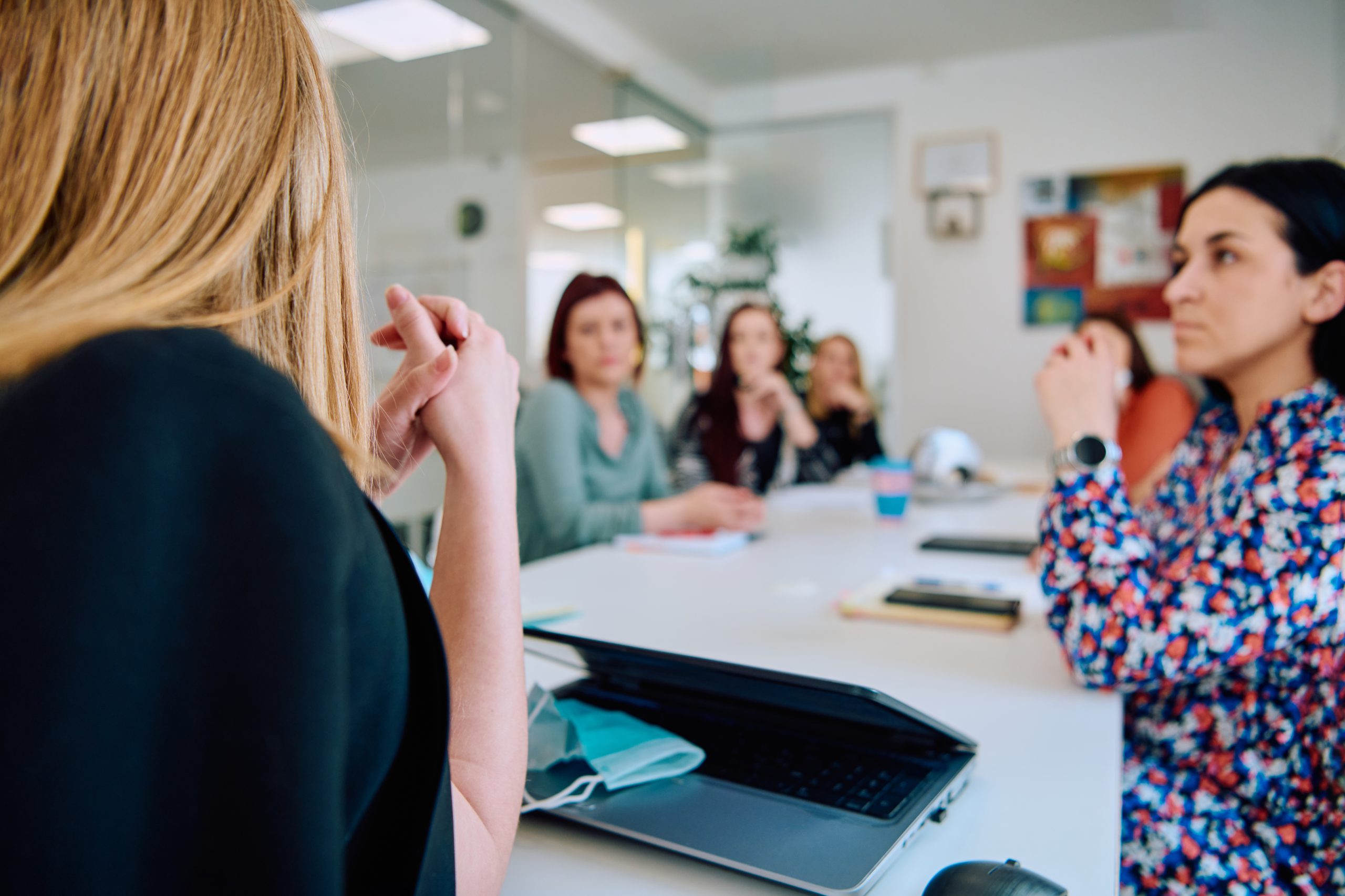 Diverse Business Team Discussing Projects in a Modern Glass Office.