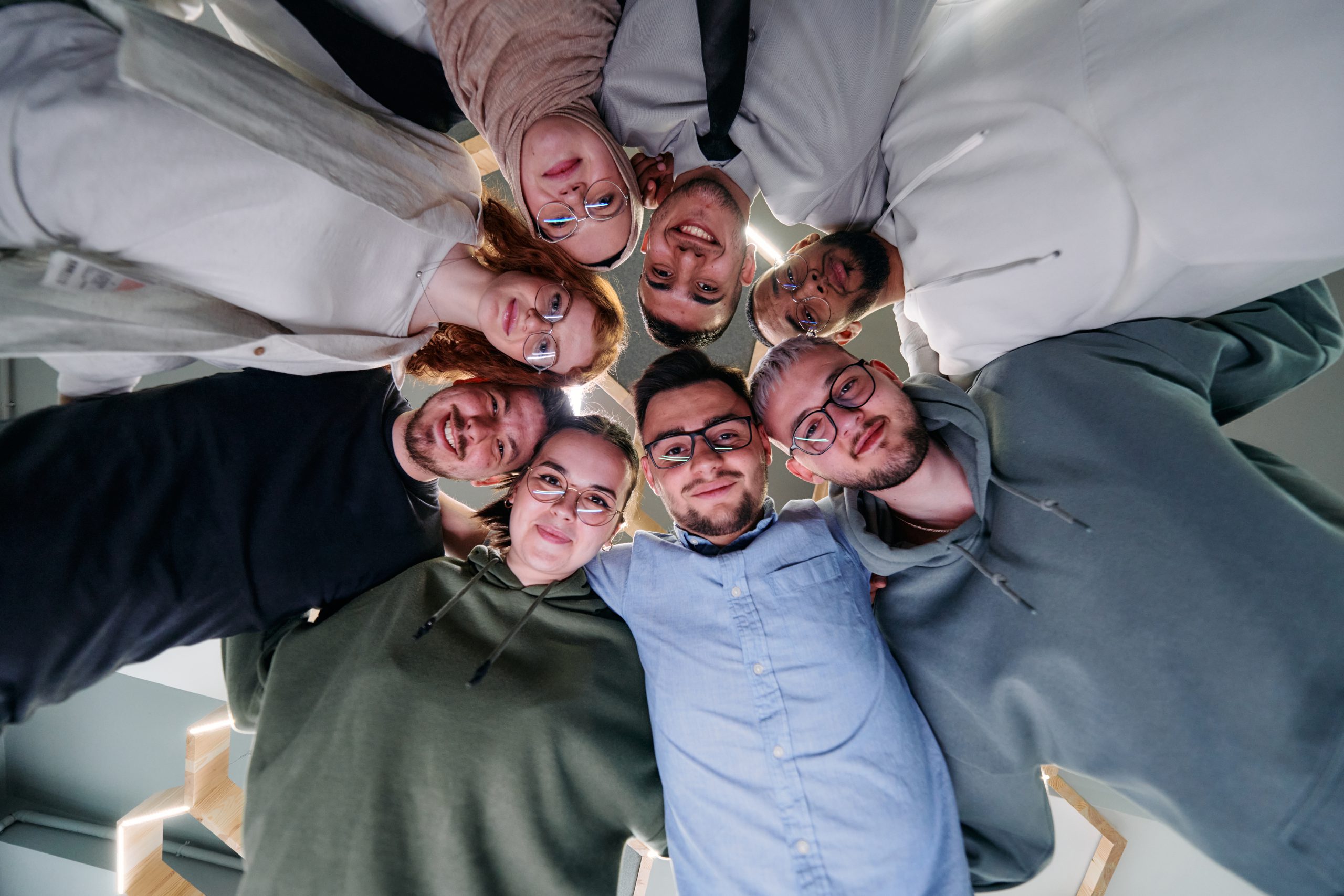 In a modern office, a group of young business professionals is captured in a warm and embracing hug, reflecting the spirit of unity, collaboration, and shared success in their dynamic workplace.